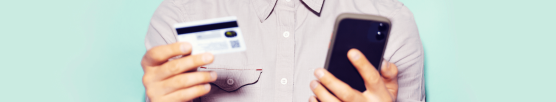 man holding credit card and mobile phone