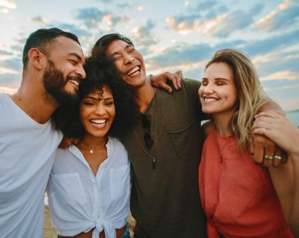 group of friends hugging with sky in background